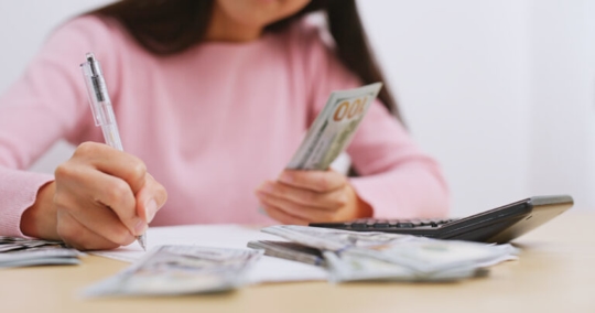 Woman counting money at home.